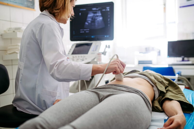 Female patient undergoing abdominal ultrasound screening.
